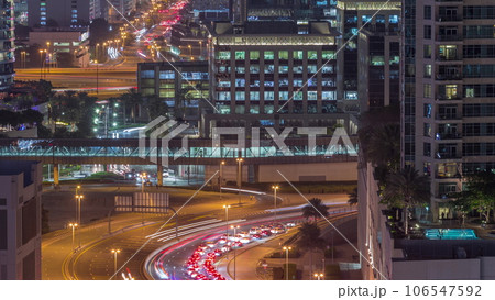 Top aerial view of busy road intersection and traffic junctions in Dubai city night timelapse. 106547592