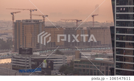 Construction site around Dubai water canal with many cranes aerial timelapse. 106547611