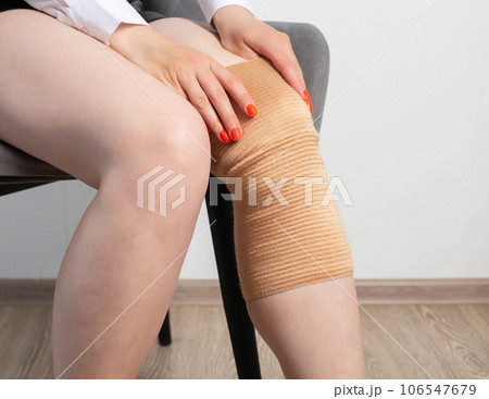 Orthopedic medical kneecap on the leg of a girl. Fixation and support of the knee joint after injury. 106547679