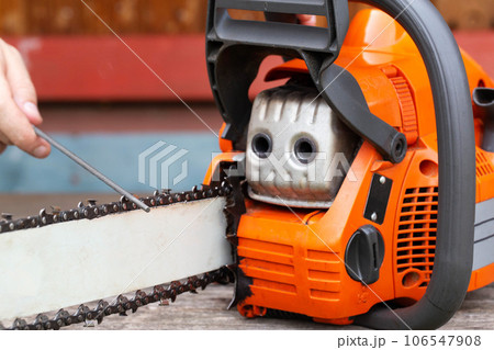 chainsaw chain sharpening with a special file. Dulling an old chain on a chainsaw bar. Industry 106547908
