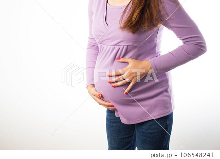 Pregnant girl holding on to her swollen belly on a white background. The concept of flatulence and intestinal problems in pregnant women. Copy space for text 106548241