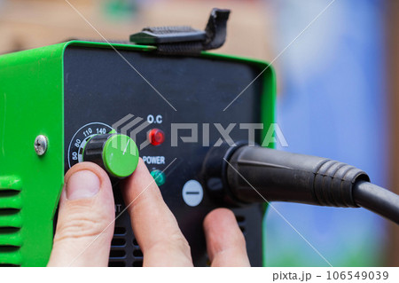 Adjusting the current strength on a modern welding machine. Welding arc. Close-up 106549039