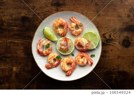 Shrimps, overhead flat lay shot. Fried shrimp with lime on a white plate Shrimps, overhead flat lay shot. Fried shrimp with lime on a white plate 106549324