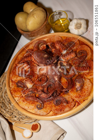 Octopus Typical Spanish dish served with paprika, salt, potatoes and olive oil Octopus Typical Spanish dish served with paprika, salt, potatoes and olive oil 106551861