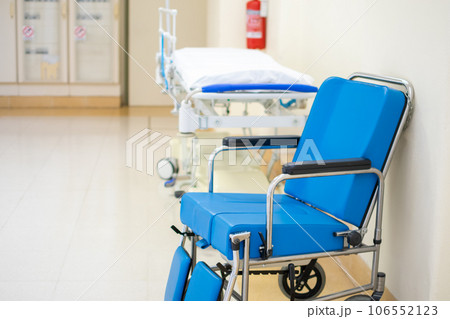 Specialized blue padded Wheelchair with Hospital stretcher in corridor background 106552123