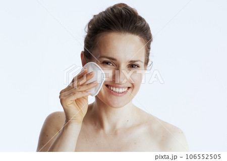 smiling modern female with cotton pad on white 106552505
