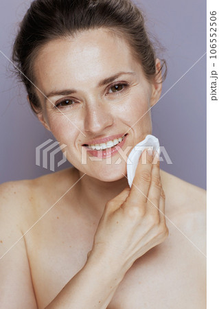 smiling modern woman with cotton pad on blue 106552506