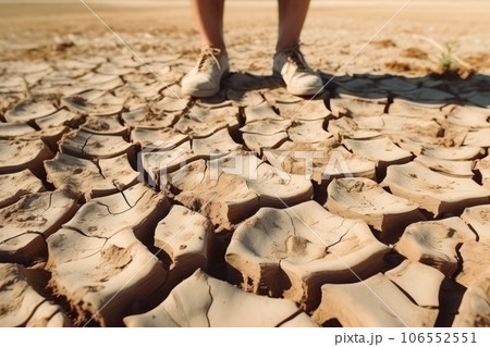 Male feet standing on parched landscape. Drought, disaster and crop failure. 106552551
