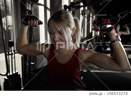Fitness woman working out in gym doing exercise for biceps. Athletic girl training .Beautiful fitness woman lifting dumbbells . Fitness sporty woman showing her well trained body Fitness woman working out in gym doing exercise for biceps. Athletic girl training .Beautiful fitness woman lifting dumbbells . Fitness sporty woman showing her well trained body 106553278