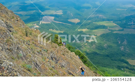 Hike on the peak of rocks mountain. Hiking in the mountains. Tourists with a backpack in mountain panorama Hike on the peak of rocks mountain. Hiking in the mountains. Tourists with a backpack in mountain panorama 106554128