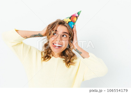 Cute happy young woman wearing party hat smiles 106554179