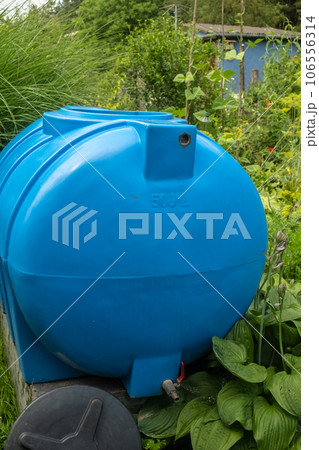 water collection tank under a roof with a drain. Rain water harvesting 106556314