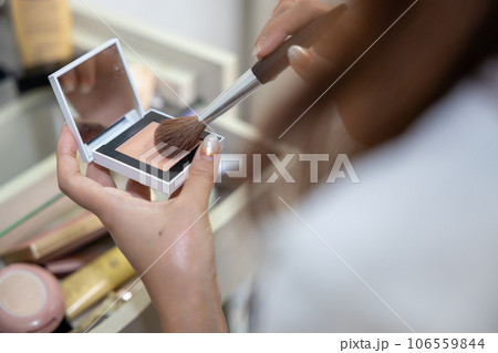 ドレッサーの前でお化粧をしている若い女性 106559844