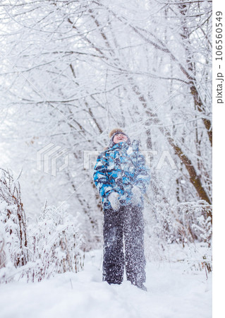 boy throwing snow in the air at sunny winter day, back view boy throwing snow in the air at sunny winter day, back view 106560549