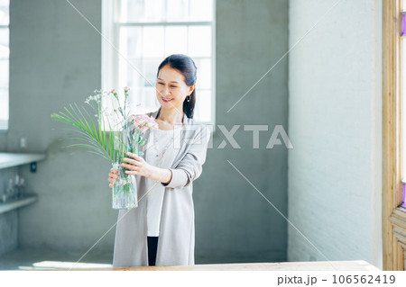 笑顔で花を生けるシニア女性 笑顔で花を生けるシニア女性 106562419