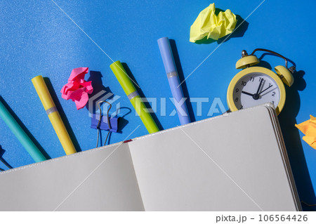 Frame border made of empty white paper notebook school stationery supplies and alarm clock. Copy space for your text or Educational greeting announcement for students and teacher. Creative vivid Frame border made of empty white paper notebook school stationery supplies and alarm clock. Copy space for your text or Educational greeting announcement for students and teacher. Creative vivid 106564426
