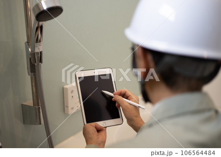 新築一戸建ての定期点検で浴室の点検をしている業者の男性 106564484
