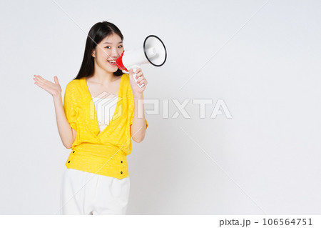 Young woman holding megaphone isolated on white background. Lifestyle summer and announce concept. Young woman holding megaphone isolated on white background. Lifestyle summer and announce concept. 106564751