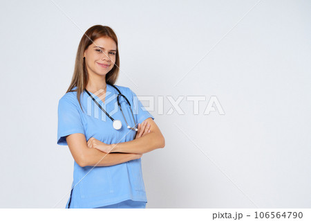 Portrait of smiling woman doctor in blue coat posing with folded arms isolated over white Background. Portrait of smiling woman doctor in blue coat posing with folded arms isolated over white Background. 106564790