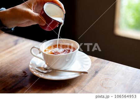 紅茶にミルクを注いているところ 紅茶にミルクを注いているところ 106564953