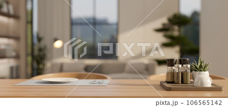 A seasoning bottle tray and a plate and cutlery on a placemat on a hardwood dining table A seasoning bottle tray and a plate and cutlery on a placemat on a hardwood dining table 106565142