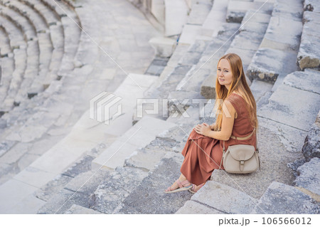 Woman tourist explores Aspendos Ancient City. Aspendos acropolis city ruins, cisterns, aqueducts and old temple. Aspendos Antalya Turkey. turkiye 106566012