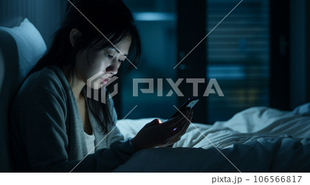 夜のベッドルームでスマホを使う日本人女性 106566817