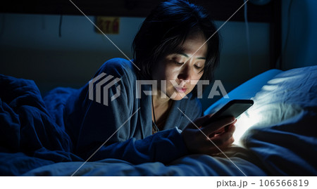 夜のベッドルームでスマホを使う日本人女性 夜のベッドルームでスマホを使う日本人女性 106566819