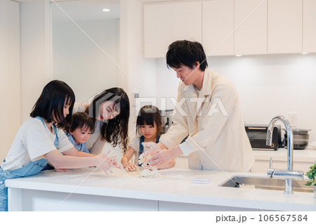 家で仲良くクッキングをする親子 106567584