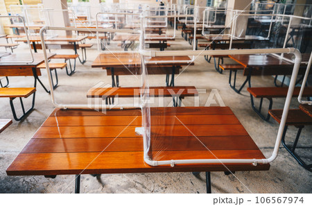 Group of plastic partition (or table shield) setting on table in canteen for reduce and protection the COVID-19 virus spreads in pandemic. Social distancing concept. 106567974