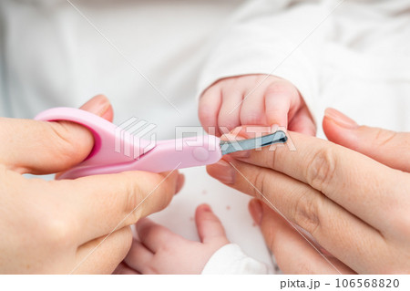 Safety in trimming newborn nails. Concept of detailed infant nail grooming Safety in trimming newborn nails. Concept of detailed infant nail grooming 106568820