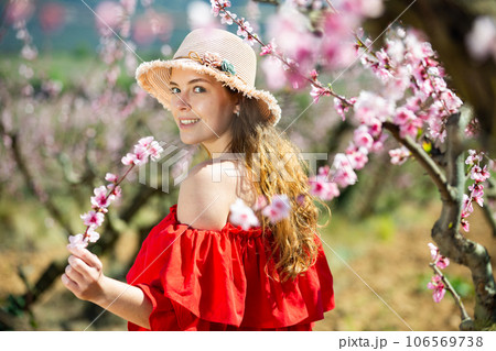 Young girl standing in spring blooming garden Young girl standing in spring blooming garden 106569738