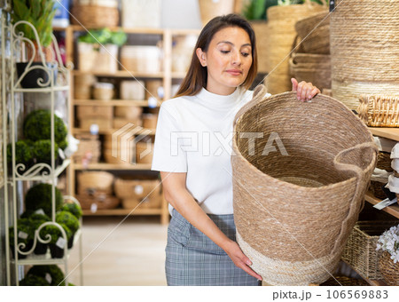 Woman choosing storage basket at household store 106569883