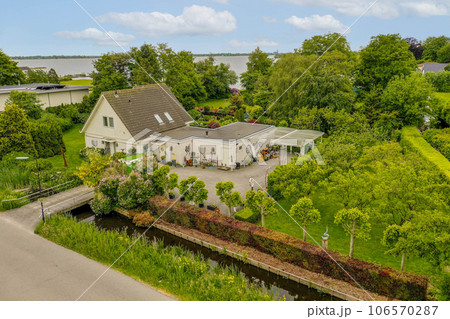 an aerial view of the house and garden from above it, with some trees in the foreground is visible on the right side 106570287