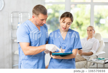 Two professional doctors discussing diagnosis of patient in medical office 106570698