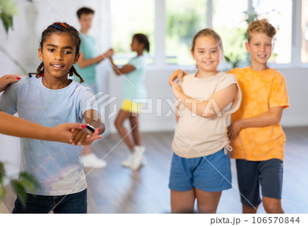 Active preteen children practicing Ballroom dances in pairs in training hall 106570844
