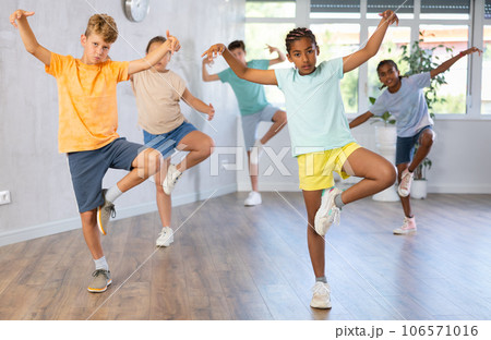 Positive smiling children studying modern style dance in class indoors Positive smiling children studying modern style dance in class indoors 106571016