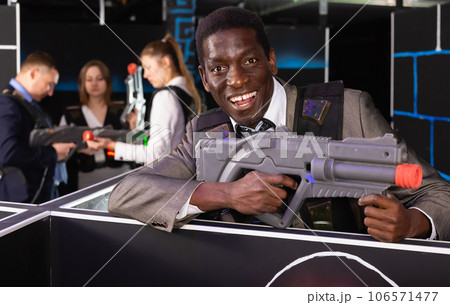Lucky Afro man and colleagues in laser tag room Lucky Afro man and colleagues in laser tag room 106571477