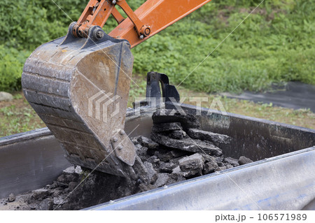 舗装工事イメージ 撤去した古いアスファルトをトラックに乗せるショベルカー 舗装工事イメージ 撤去した古いアスファルトをトラックに乗せるショベルカー 106571989