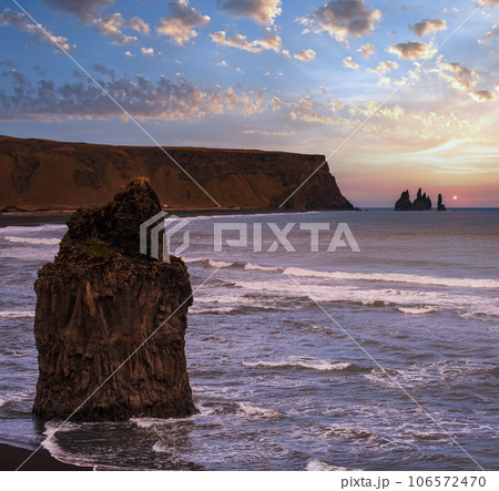 Picturesque autumn evening view to Reynisfjara ocean  black volcanic sand beach and rock formations from Dyrholaey Cape, Vik, South Iceland. Mount Reynisfjall on the background. 106572470