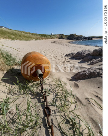 Orange buoy lying on the beach at low tide Orange buoy lying on the beach at low tide 106575166