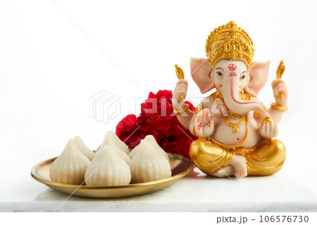 Idol of lord Ganesha with Modak Sweet Dish and flower. Ganesh chaturthi 106576730