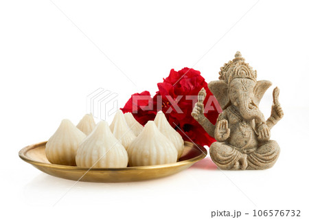 Idol of lord Ganesha with Modak Sweet Dish and flower. Ganesh chaturthi 106576732