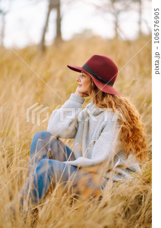 Stylish woman in hat enjoying autumn weather in the park. Fashion, style concept. 106576905