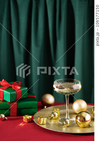 Merry Christmas and Happy New Year. Glass of champagne with golden Christmas ornaments and Christmas presents. Merry Christmas and Happy New Year. Glass of champagne with golden Christmas ornaments and Christmas presents. 106577150