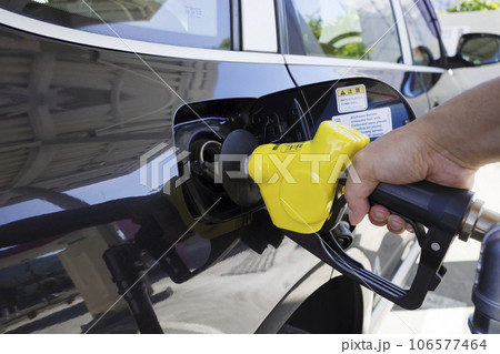 ガソリンスタンドで車に給油する人 106577464