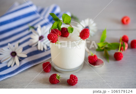 Sweet cooked homemade yogurt with fresh raspberries in a glass. Sweet cooked homemade yogurt with fresh raspberries in a glass. 106579124