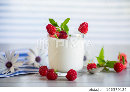 Sweet cooked homemade yogurt with fresh raspberries in a glass. Sweet cooked homemade yogurt with fresh raspberries in a glass. 106579125