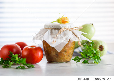 Cooked zucchini caviar with tomatoes in a glass jar,. Cooked zucchini caviar with tomatoes in a glass jar,. 106579127