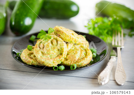 Fried squash green pancakes in a plate. Fried squash green pancakes in a plate. 106579143